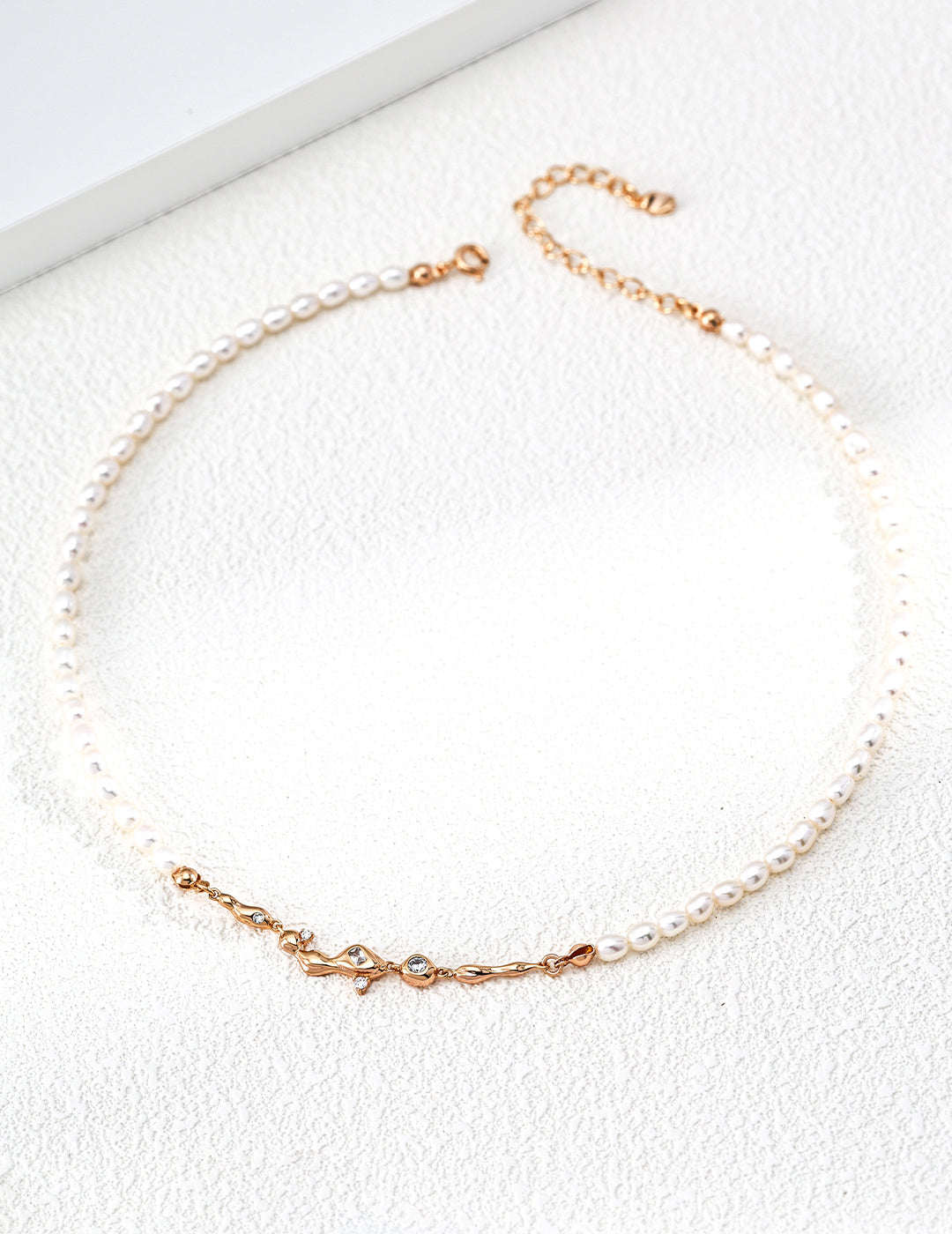 A professional studio shot of the Astra pearl necklace in vintage gold. This image highlights the "pearl-as-star" concept, showing the alternating pattern of natural 4*5mm pearls against the delicate silver chain.